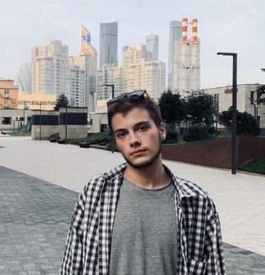 Person standing in front of a city skyline with modern buildings.